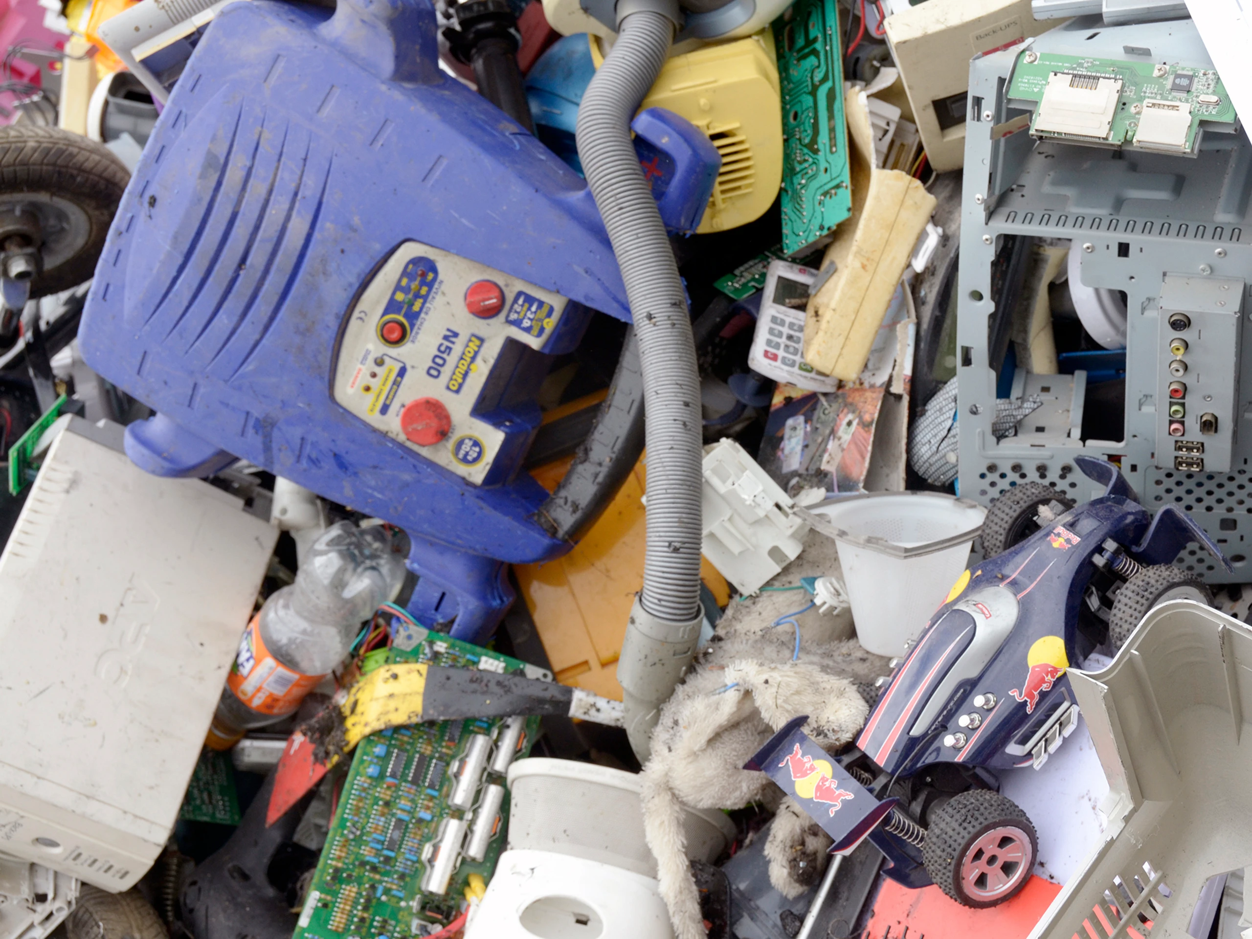 Close-up van gemengd e-afval: printplaten, kleine huishoudtoestellen, kabels en kunststof onderdelen