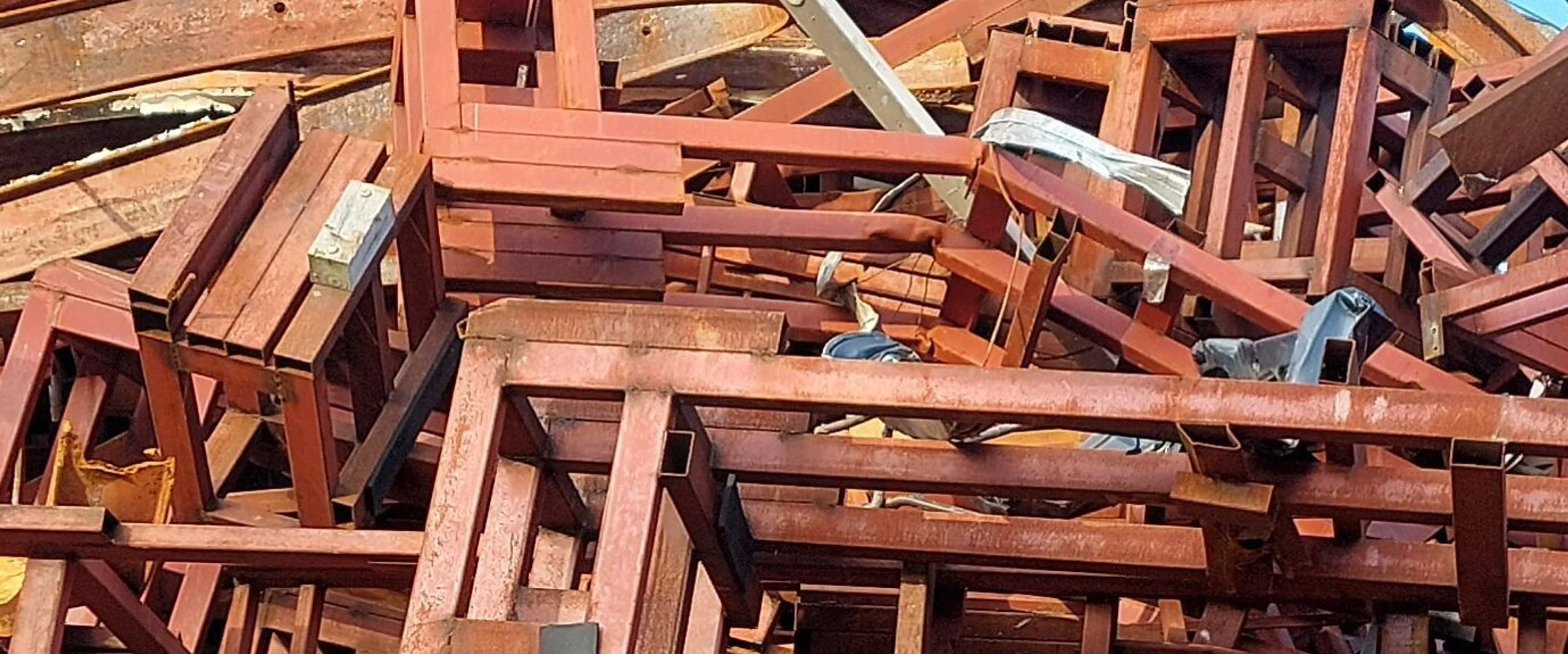 Gestapelde roestkleurige stalen profielen en frames