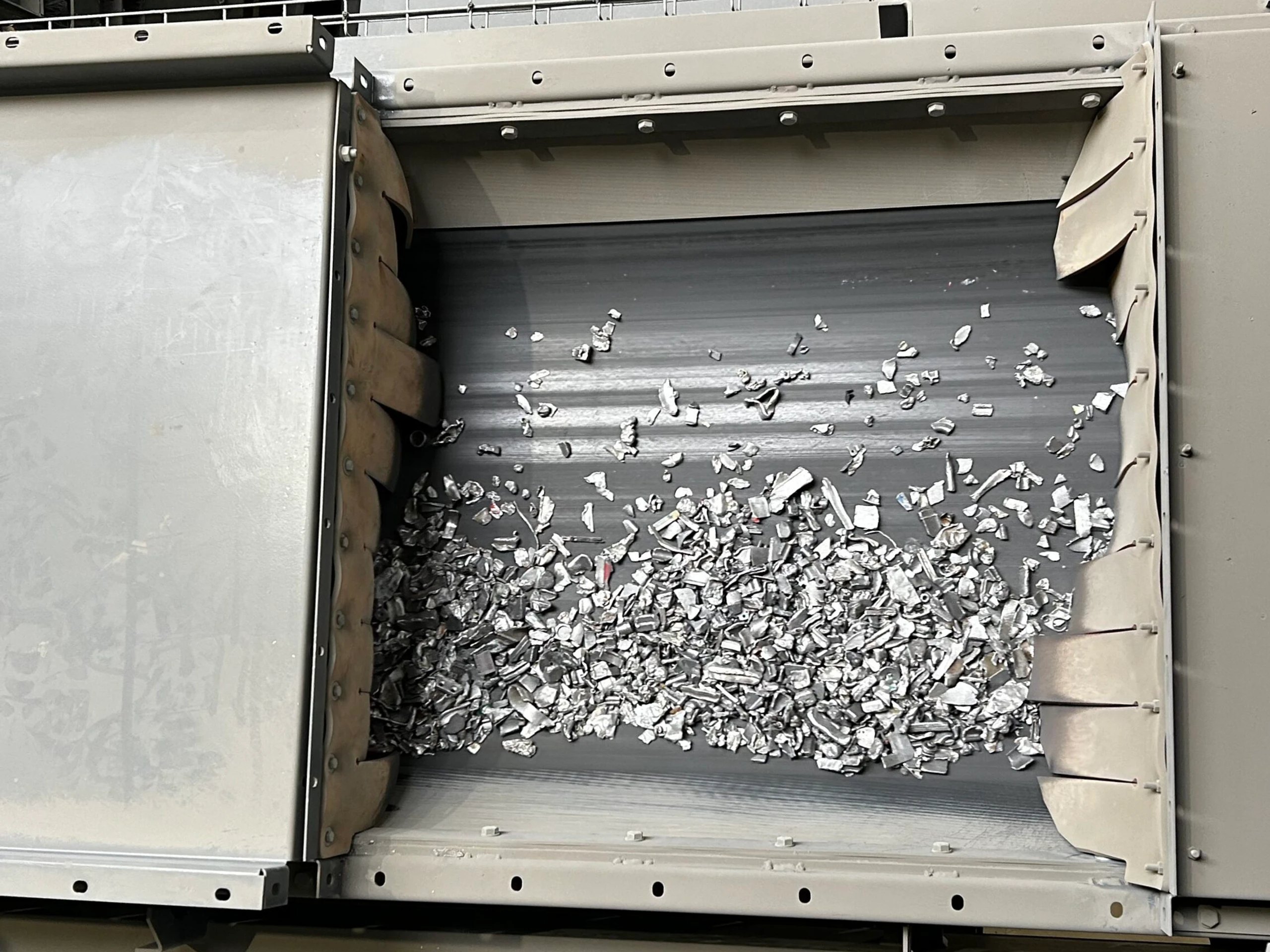 Metaalfragmenten op transportband na scheiding/verwerking