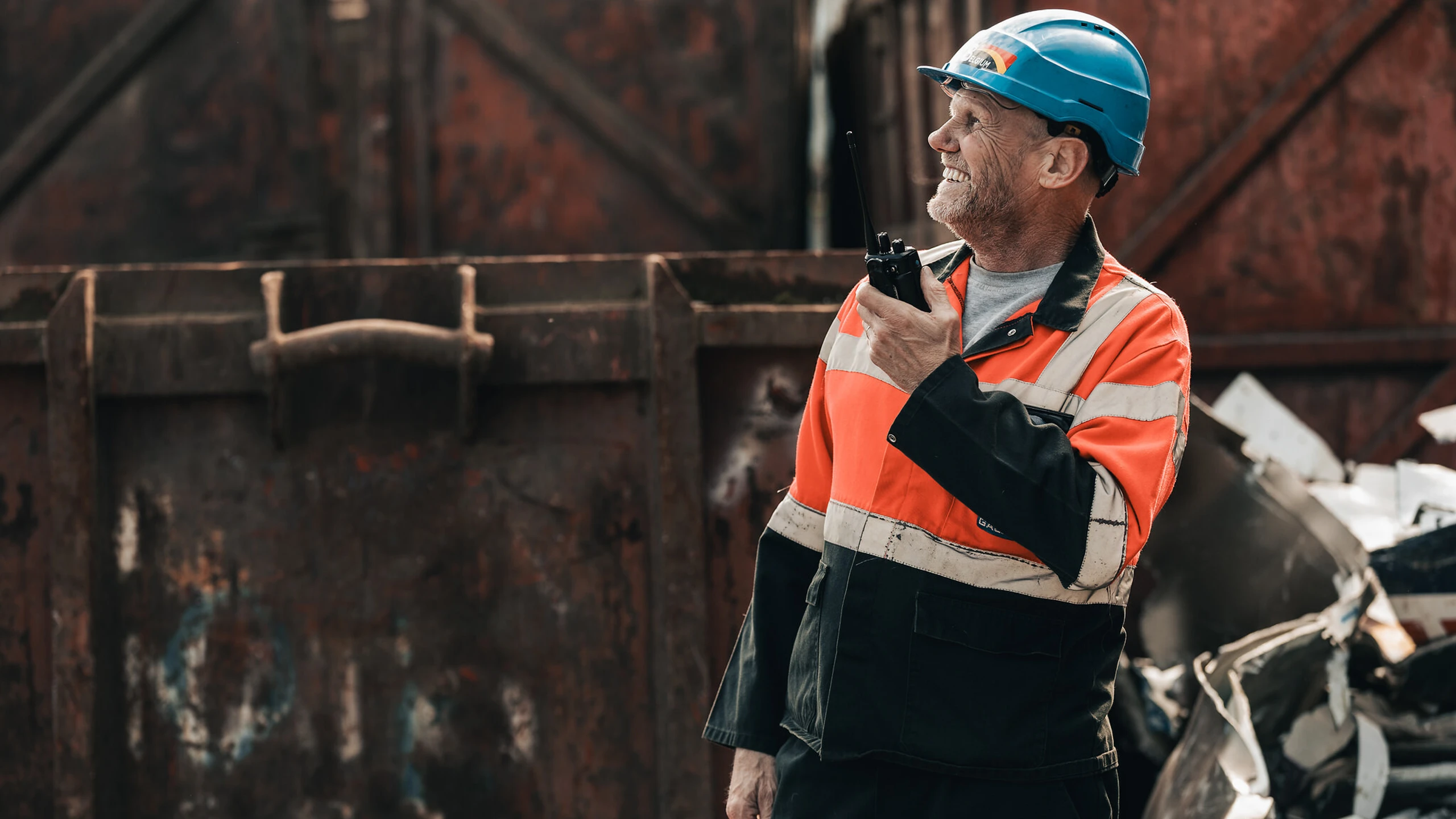 Galloo medewerker met blauwe helm communiceert via portofoon op het terrein